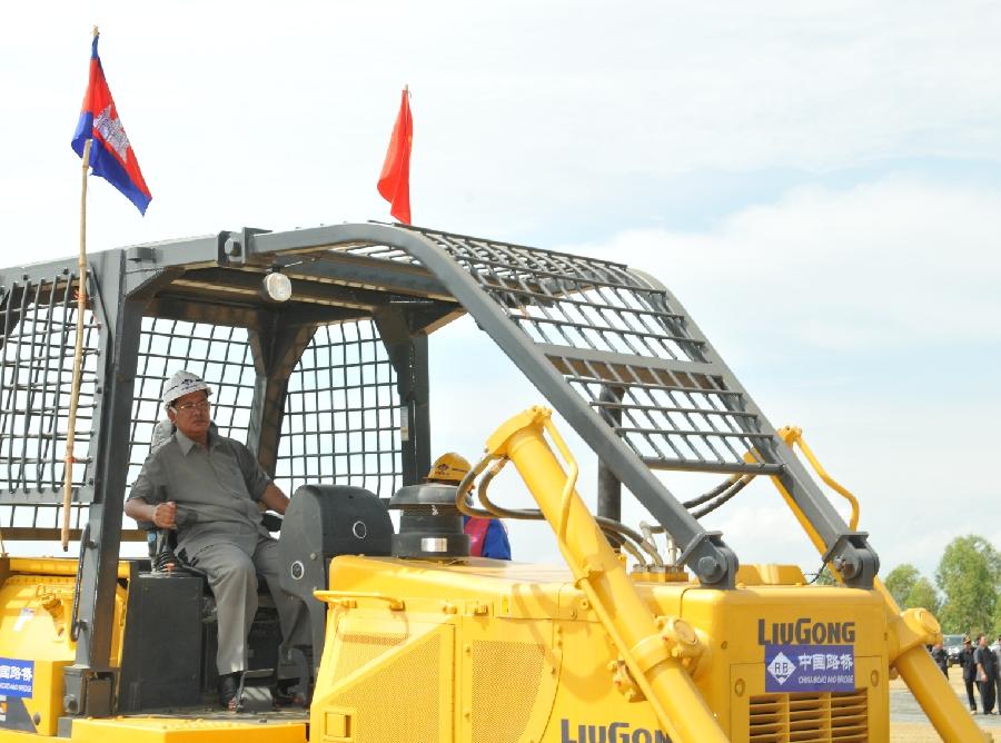 Cambodian Primie Minister Hun Sen drives a bulldozer during the inauguration ceremony of a road construction project in western Kampong Speu province, Cambodia, May 6, 2013. Cambodian Prime Minister Hun Sen on Monday broke ground for the construction of a 140-kilometer stretch of the national road No. 44 under Chinese financial support. (Xinhua/Li Hong) 