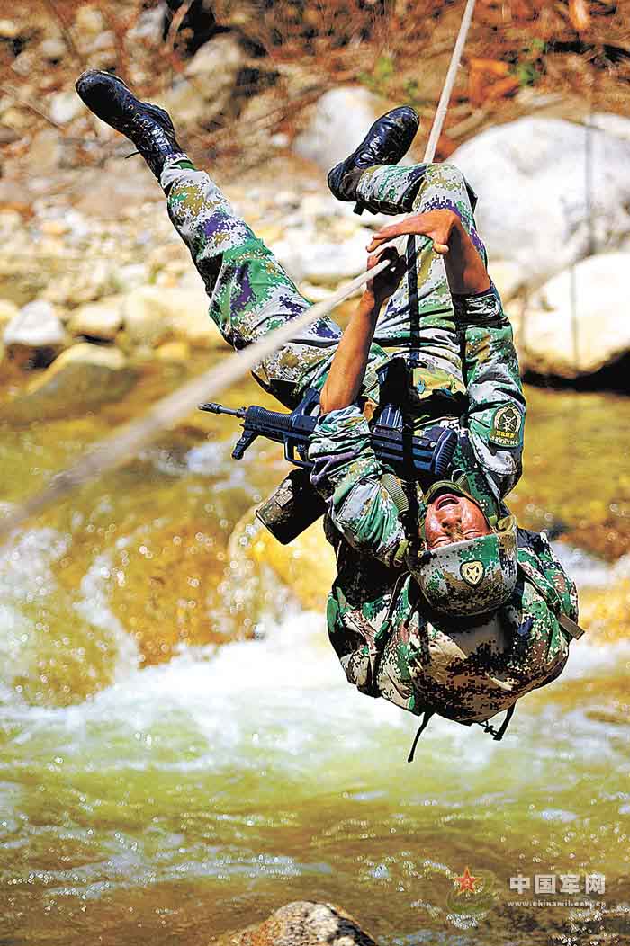 A mountain brigade of the Chinese People's Liberation Army (PLA) stationed in Tibet organized its reconnaissance troops to conduct a two-month-long bivouacked training in deep mountains along the Yalu Zangbo River on May 2, 2013. The photo shows that a scout is crossing a river by climbing a rope. (Chinamil.com.cn/Zhao Haibo)