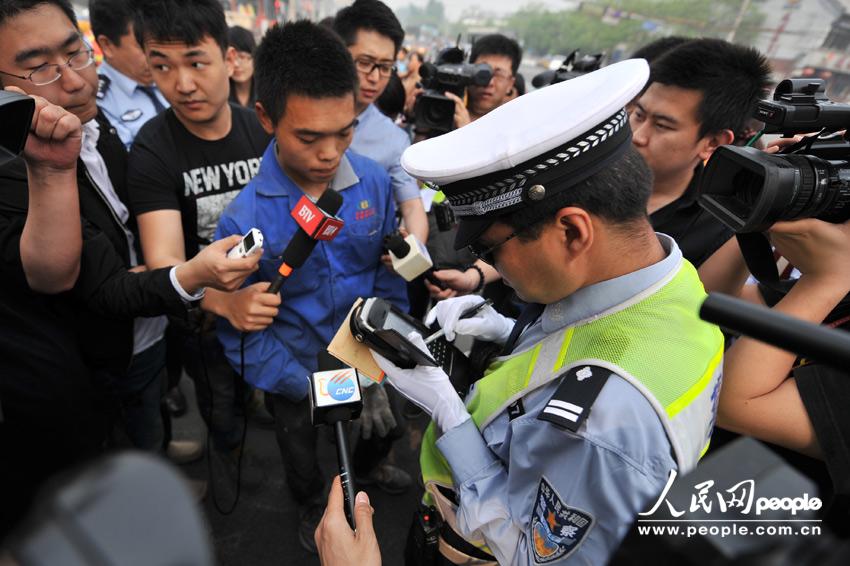 A tricyclist who rides on a motorway is fined 20 yuan ($3.20) at an intersection in Beijing, May 6, 2013. (Weng Qiyu /People’s Daily Online)