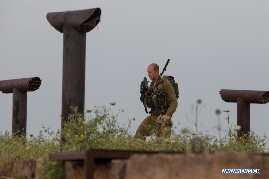 An Israeli soldier in an abandoned military outpost overlooks the ceasefire line between Israel and Syria on the Israeli-occupied Golan Heights May 6, 2013. Israel Defense Forces (IDF) reported that 2 stray mortars shot from Syria landed in Golan Heights on Monday.(Xinhua/Jini)