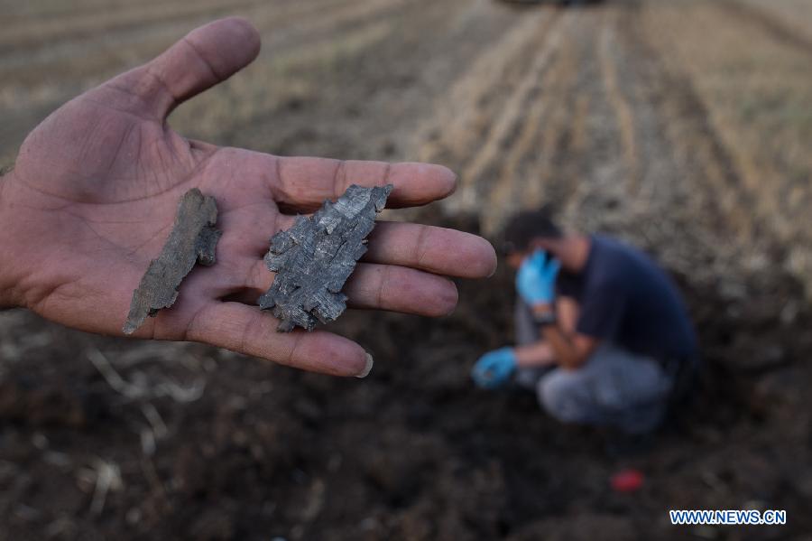 An Israeli man shows shrapnel of mortar shells that fired from Syria and landed near the Israel-Syria ceasefire line, in the southern Golan Heights, May 6, 2013. Israel Defense Forces (IDF) reported that 2 stray mortars shot from Syria landed in Golan Heights on Monday.(Xinhua/Jini)