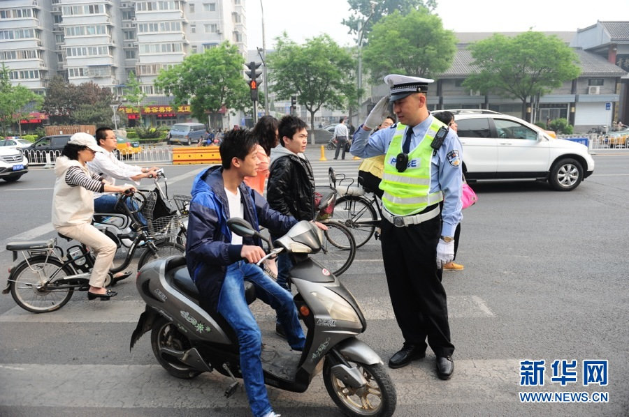Traffic policeman stops a traffic rule-breaker at an intersection in Beijing, May 6, 2013. (Xinhua/Li Xin)