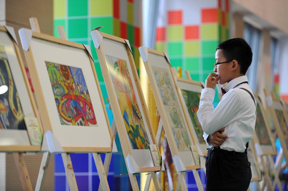 A child views award-winning creations in Hangzhou, Zhejiang province on April 29, 2013. The 8th China International Children's Cartoon Contest attracted 34,620 works by children and teenagers from 39 countries in the world. (Xinhua Photo/ Ju Huanzong)
