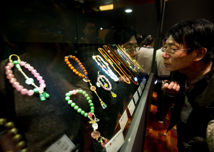 A man looks at jewellries during the preview of China Guardian 2013 Spring Auctions in Beijing, capital of China, May 7, 2013. The three-day preview that opened on Tuesday displayed some 3,900 treasures to be auctioned on Friday. (Xinhua/Luo Xiaoguang) 
