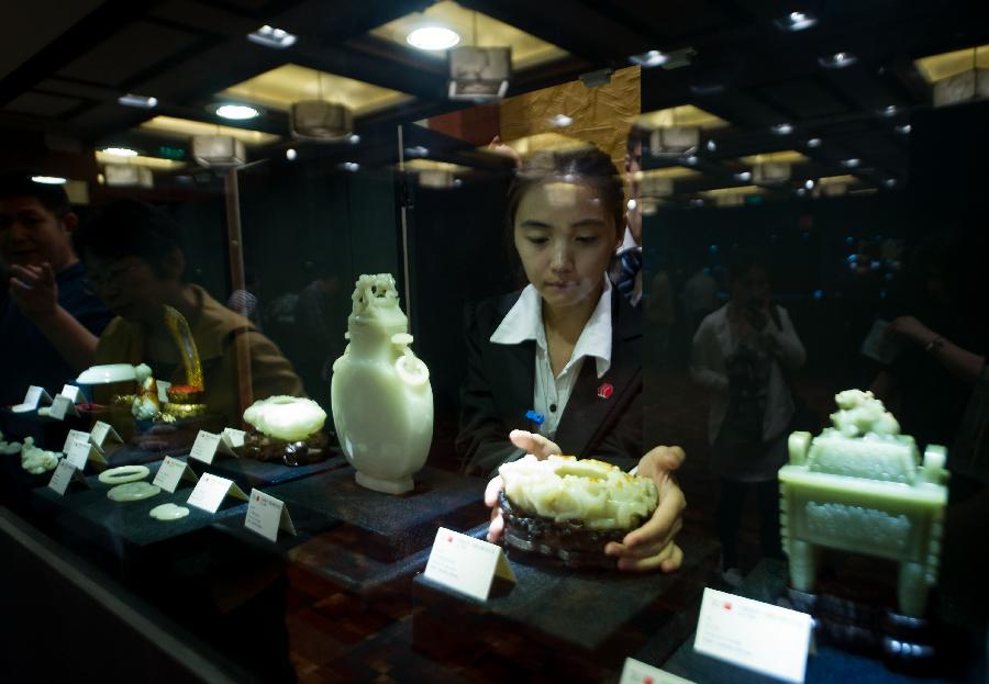 An exhibitor arranges a jade work during the preview of China Guardian 2013 Spring Auctions in Beijing, capital of China, May 7, 2013. The three-day preview that opened on Tuesday displayed some 3,900 treasures to be auctioned on Friday. (Xinhua/Luo Xiaoguang)