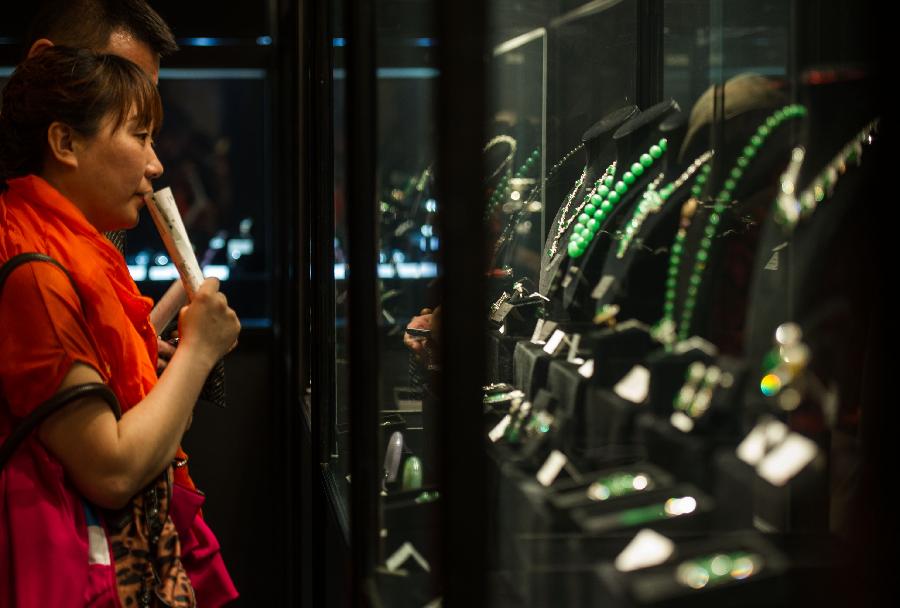 A woman looks at jewellries during the preview of China Guardian 2013 Spring Auctions in Beijing, capital of China, May 7, 2013. The three-day preview that opened on Tuesday displayed some 3,900 treasures to be auctioned on Friday. (Xinhua/Luo Xiaoguang) 