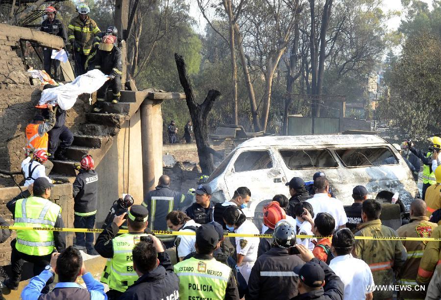 Firemen carry the body of a victim out of the site of an explosion on the Mexico-Pachuca highway in Ecatepec, Mexico, on May 7, 2013. At least 20 people were killed and 34 injured when a gas tanker exploded early Tuesday in a Mexico City suburb, security officials said. (Xinhua/Susana Martinez) 