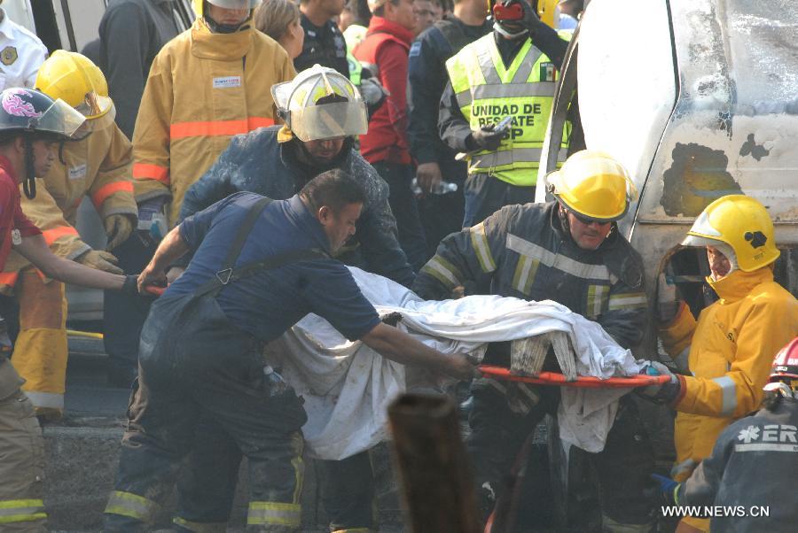 Rescuers remove the body of a victim from the site of an explosion on the Mexico-Pachuca highway in Ecatepec, Mexico, on May 7, 2013. At least 20 people were killed and 34 injured when a gas tanker exploded early Tuesday in a Mexico City suburb, security officials said. (Xinhua/Susana Martinez) 