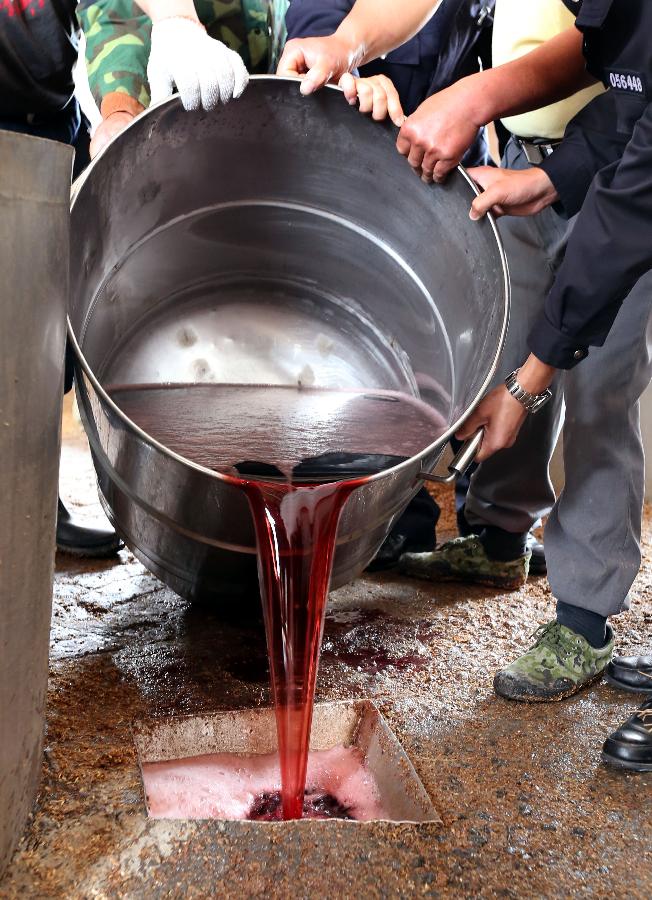 Police destroy counterfeit red wines in Shanghai, east China, May 7, 2013. Local police smashed over 3,000 bottles of counterfeit red wines worth of more than 40 million Yuan (approximately 6.5 million US dollars). (Xinhua/Fan Jun) 