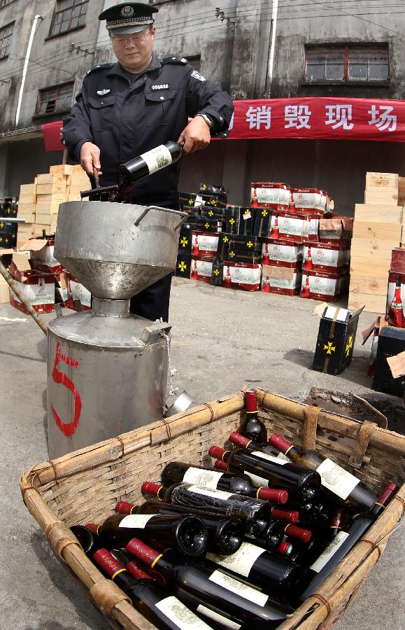 Police destroy counterfeit red wines in Shanghai, east China, May 7, 2013. Local police smashed over 3,000 bottles of counterfeit red wines worth of more than 40 million Yuan (approximately 6.5 million US dollars). (Xinhua/Fan Jun) 