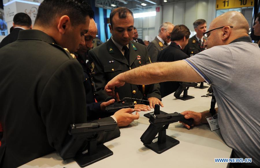 Military officers visit the booth of a gun company from Austria in Istanbul, Turkey, May 7, 2013. The 11th International Defence Industry Fair was opened on Tuesday, with 781 companies from 82 countries and regions attending the four-day fair. (Xinhua/Lu Zhe) 
