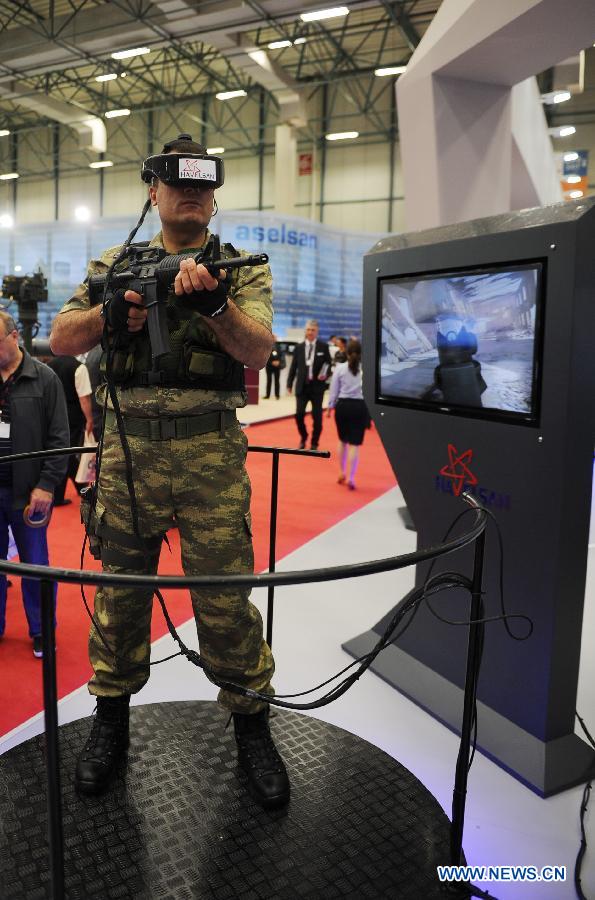 A soldier shows the virtual combat training system made by a Turkish company in Istanbul, Turkey, May 7, 2013. The 11th International Defence Industry Fair was opened on Tuesday, with 781 companies from 82 countries and regions attending the four-day fair. (Xinhua/Lu Zhe)