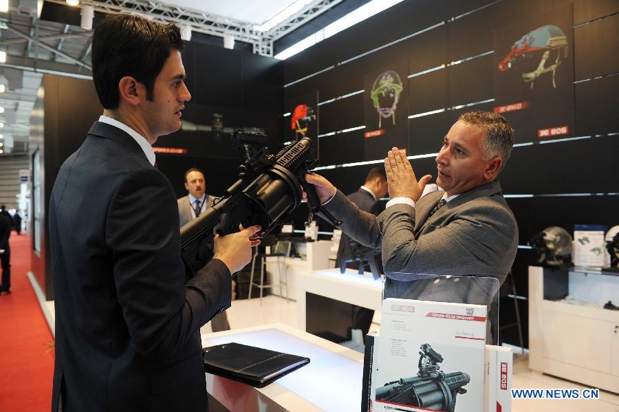 A guest asks questions at firearms Company booth in Istanbul, Turkey, May 7, 2013. The 11th International Defence Industry Fair was opened on Tuesday, with 781 companies from 82 countries and regions attending the four-day fair. (Xinhua/Lu Zhe) 