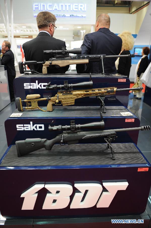 People visit a sniper rifles booth from Finland in Istanbul, Turkey, May 7, 2013. The 11th International Defence Industry Fair was opened on Tuesday, with 781 companies from 82 countries and regions attending the four-day fair. (Xinhua/Lu Zhe)