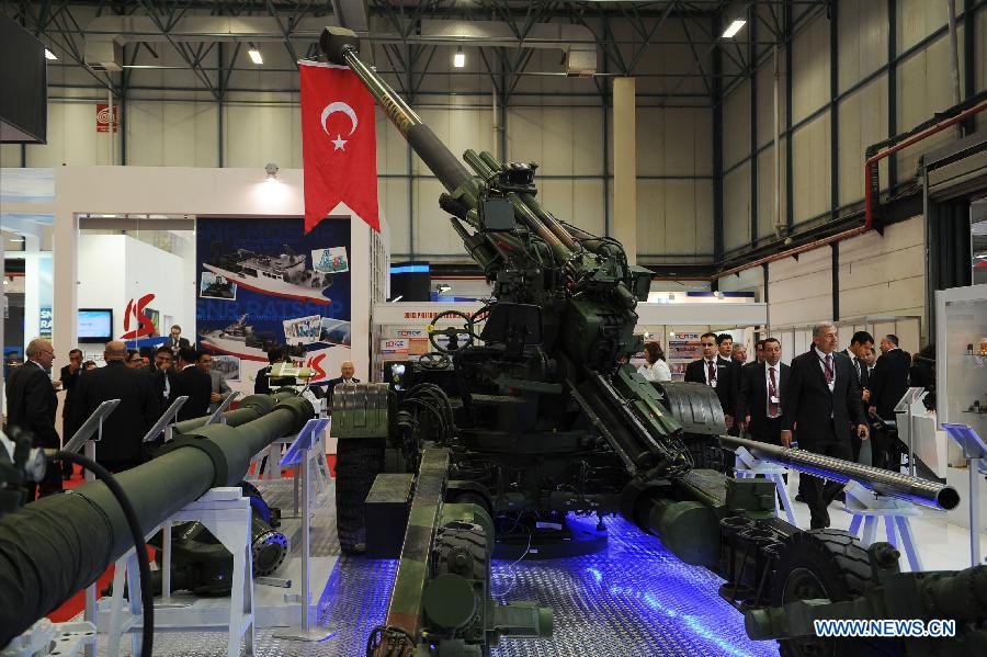 Visitors pass a towed howitzer produced by a Turkish company in Istanbul, Turkey, May 7, 2013. The 11th International Defence Industry Fair was opened on Tuesday, with 781 companies from 82 countries and regions attending the four-day fair. (Xinhua/Lu Zhe)