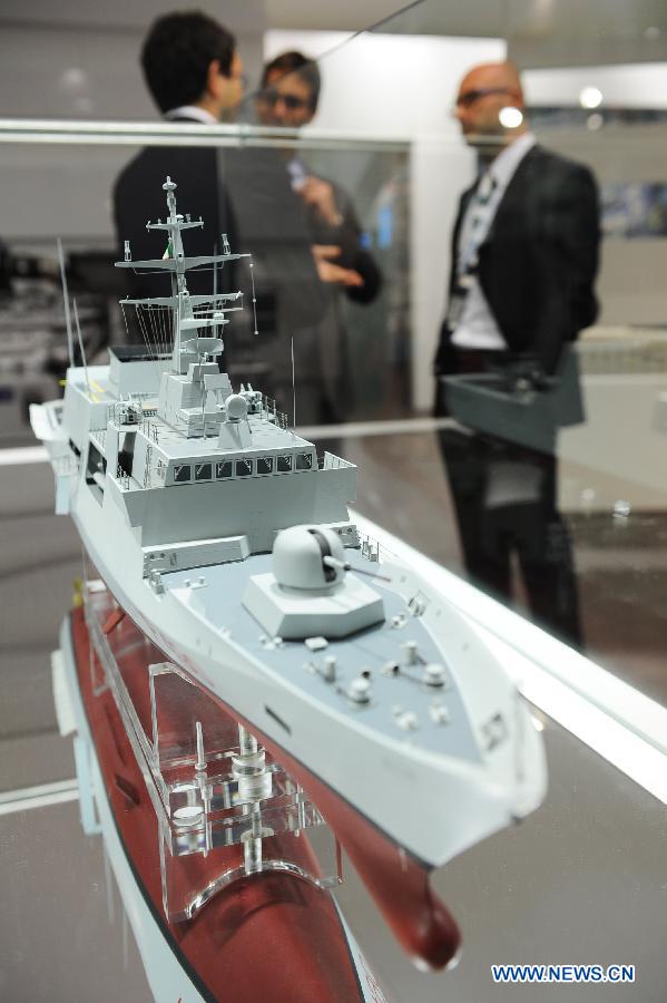Guests talk with each other in front of an Italian company's warship model in Istanbul, Turkey, May 7, 2013. The 11th International Defence Industry Fair was opened on Tuesday, with 781 companies from 82 countries and regions attending the four-day fair. (Xinhua/Lu Zhe) 