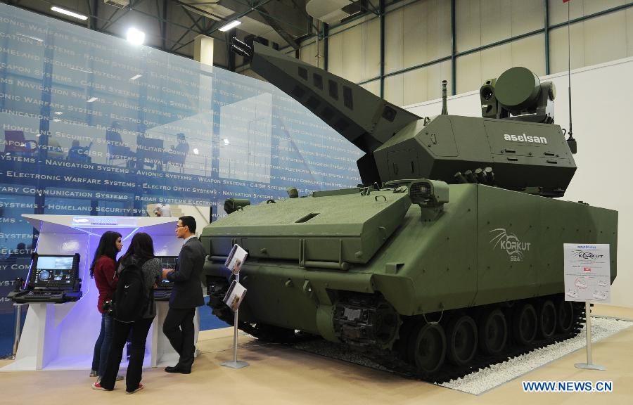 Guests view an armored vehicle of fire control system made by a Turkish company in Istanbul, Turkey, May 7, 2013. The 11th International Defence Industry Fair was opened on Tuesday, with 781 companies from 82 countries and regions attending the four-day fair. (Xinhua/Lu Zhe)