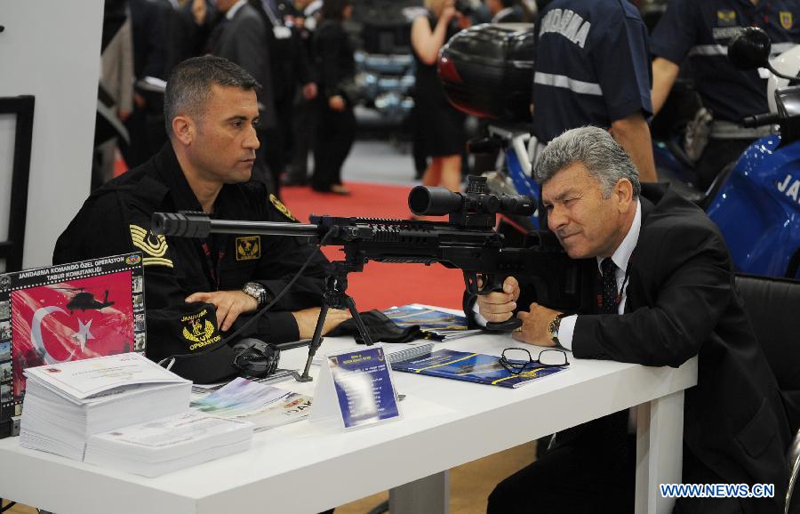 A guest experiences a sniper rifle in Istanbul, Turkey, May 7, 2013. The 11th International Defence Industry Fair was opened on Tuesday, with 781 companies from 82 countries and regions attending the four-day fair. (Xinhua/Lu Zhe)