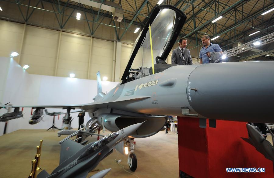 A representative of the Turkish company introduces the F-16 fighter to a visitor in Istanbul, Turkey, May 7, 2013. The 11th International Defence Industry Fair was opened on Tuesday, with 781 companies from 82 countries and regions attending the four-day fair. (Xinhua/Lu Zhe)