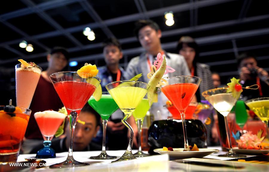 People look at various cocktails displayed at the 15th International Exhibition of Food & Drink, Hotel, Restaurant & Food Service Equipment, Supplies & Services (HOFEX) in south China's Hong Kong, May 7, 2013. The four-day HOFEX 2013 kicked off on Tuesday at Hong Kong Convention & Exhibition Center. (Xinhua/Chen Xiaowei)