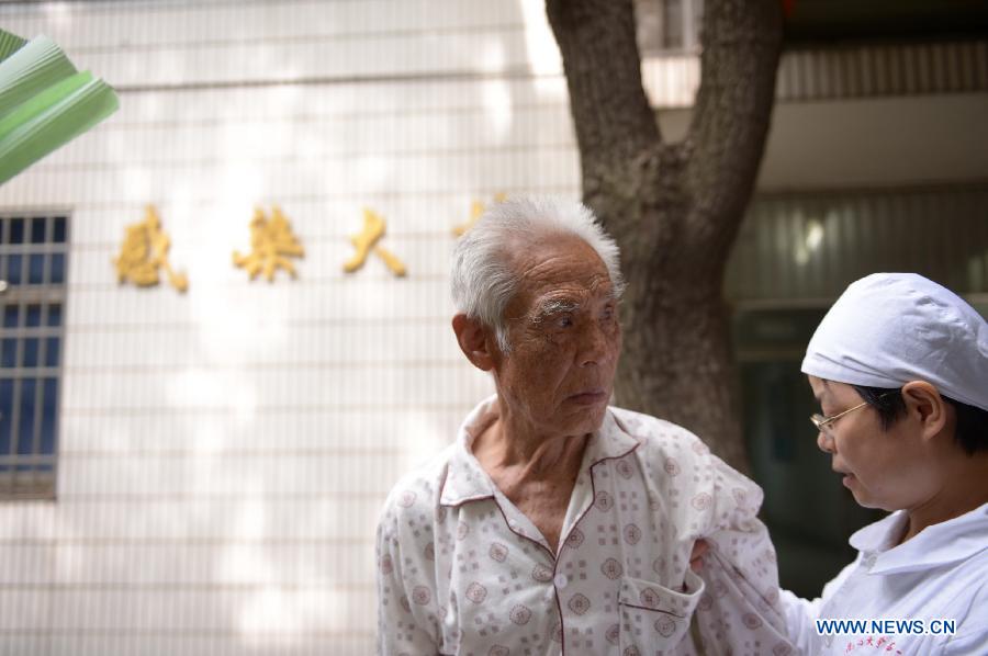 An 80-year-old H7N9 avian influenza patient, who has made full recovery, is helped to walk out of the ward in hospital in Nanchang, capital of east China's Jiangxi Province, May 8, 2013. The old man, surnamed Xiong, was discharged from the hospital on Wednesday. (Xinhua/Zhou Mi)