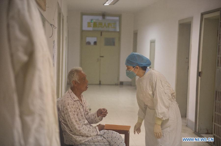 An 80-year-old H7N9 avian influenza patient, who has made full recovery, talks with a medical worker in hospital in Nanchang, capital of east China's Jiangxi Province, May 8, 2013. The old man, surnamed Xiong, was discharged from the hospital on Wednesday. (Xinhua/Zhou Mi)