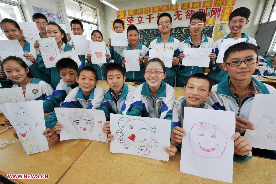Students show their paintings of smiling faces to celebrate the World Smile Day at the No. 20 Middle School in Yinchuan, capital of northwest China's Ningxia Hui Autonomous Region, May 8, 2013. (Xinhua/Peng Zhaozhi)