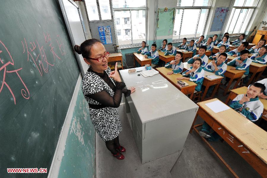 A teacher interacts with her students to show their smiles to celebrate the World Smile Day at the No. 20 Middle School in Yinchuan, capital of northwest China's Ningxia Hui Autonomous Region, May 8, 2013. (Xinhua/Peng Zhaozhi) 