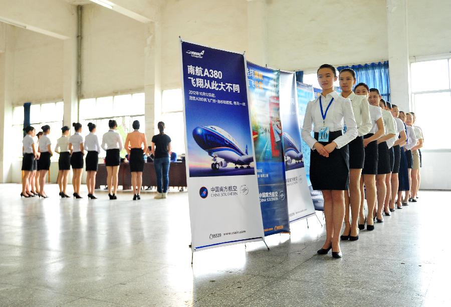 Job applicants gesture as they wait for the interview of a flight attendent recruitment in Wuhan, capital of central China's Hubei Province, May 8, 2013. (Xinhua/Xiao Yijiu)