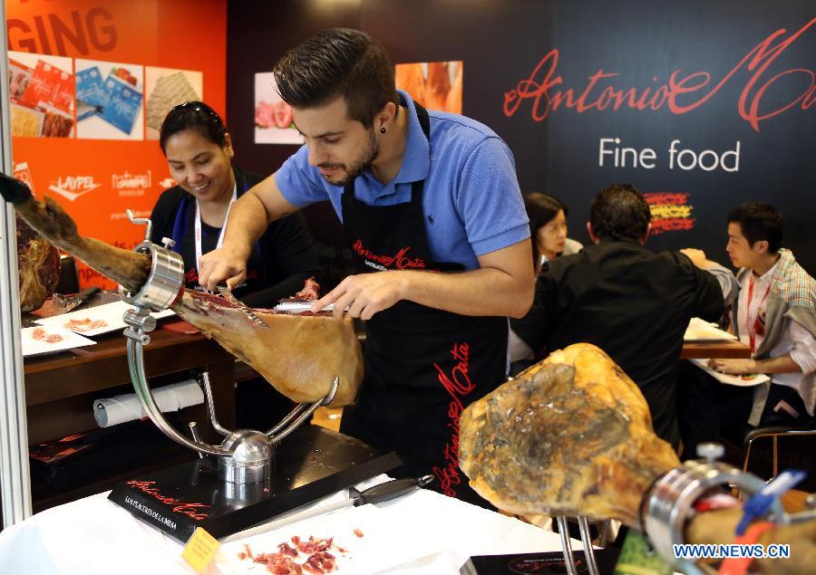 A foreign exhibitor works on a western-style ham during the 15th International Exhibition of Food & Drink, Hotel, Restaurant & Food Service Equipment, Supplies & Services (HOFEX) in south China's Hong Kong, May 8, 2013. The four-day HOFEX 2013 will last till May 10 at Hong Kong Convention & Exhibition Center. (Xinhua/Li Peng)