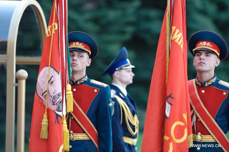 Russian soldiers stand with flags in their hands during a wreath laying ceremony at the Tomb of the Unknown Martyrs in Moscow, on May 8, 2013, to commemorate the Patriotic War of the Soviet Union. (Xinhua/Jiang Kehong)