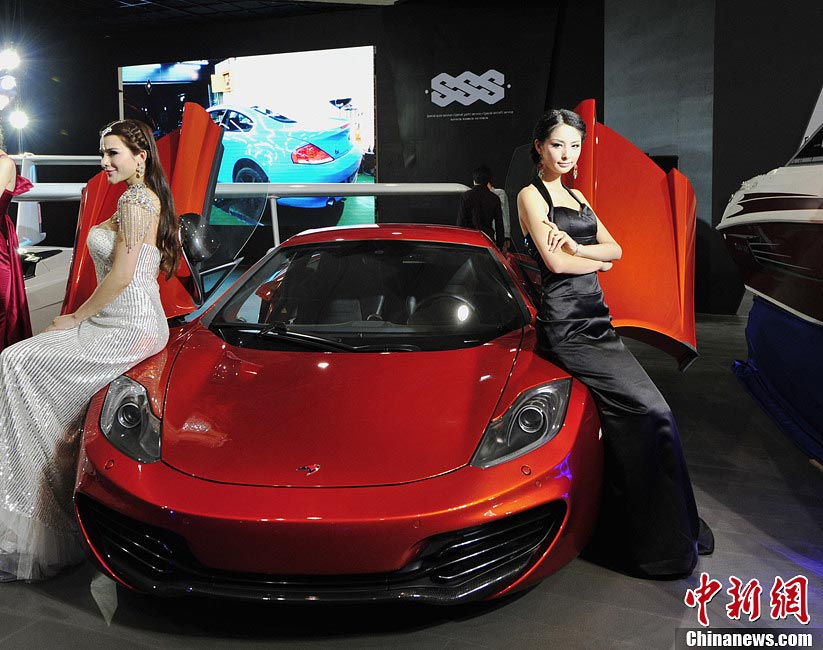 Auto models stand beside automobile at the show. (Photo/CNS)