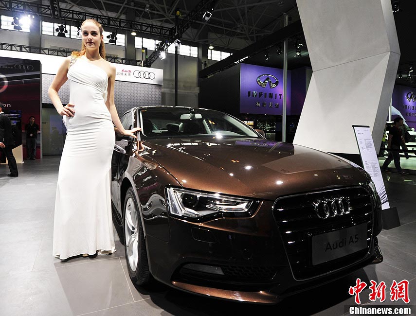 Auto model stands beside automobile at the show. (Photo/CNS)