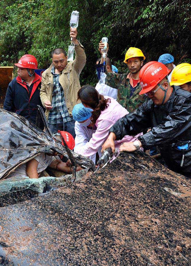Rescuers help passengers trapped in a car after a landslide on S210 road from Lushan County to Baoxing County, southwest China's Sichuan Province, May 9, 2013. Three were killed among the nine people trapped by the landslide which took place Thursday near the epicenter of a 7.0-Magnitude earthquake that struck on April 20. (Xinhua/Hua Xiaofeng)