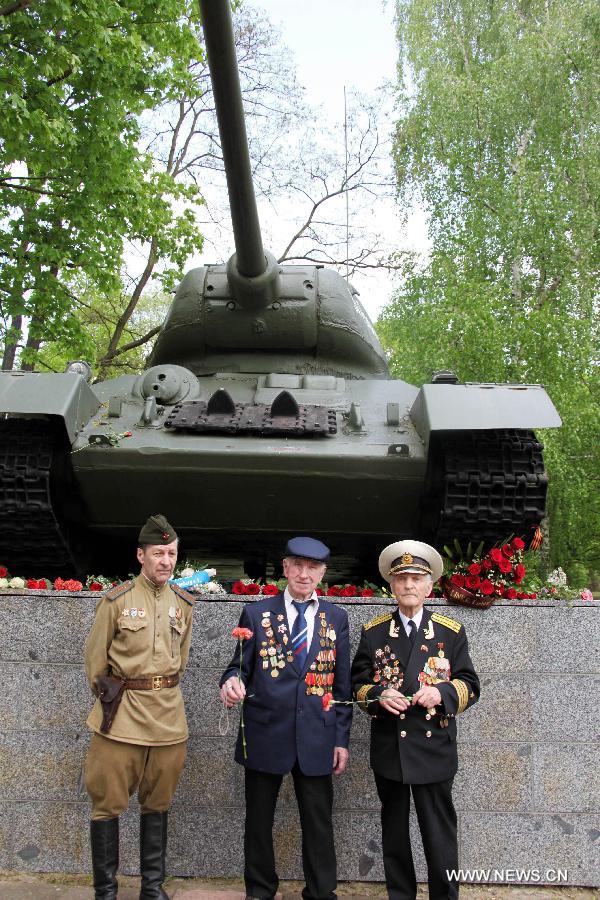 Visitors pose in front of a T-34 Tank model displayed at the German-Russian Museum in Karlshorst, Berlin, Germany, on May, 8, 2013. People from across Europe commemorated on Wednesday, in one way or another, the 68th Victory in Europe Day (VE Day) that marks the end of the Second World War (WWII) in Europe. (Xinhua/Pan Xu)