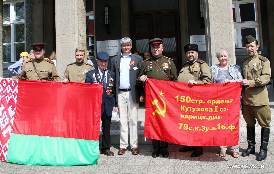 Delegates from Russia and Belarus and veterans of former Soviet Red Army hold banners and flags in front of the German-Russian Museum in Karlshorst, Berlin, Germany, on May, 8, 2013. People from across Europe commemorated on Wednesday, in one way or another, the 68th Victory in Europe Day (VE Day) that marks the end of the Second World War (WWII) in Europe. (Xinhua/Pan Xu)