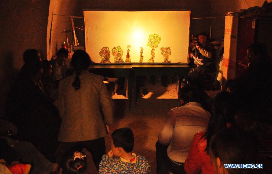 Villagers watch a Daoqing (a folk operetta originated from the chanting of Taoist scriptures) shadow play at Chenqiyuan Village in Huanxian County, Qingyang, northwest China's Gansu Province, May 8, 2013. Huanxian County, which locates in the east of Gausu Province, boasts its Daoqing shadow play. The art form is popular among local residents for its attractive performance. (Xinhua/Guo Gang)