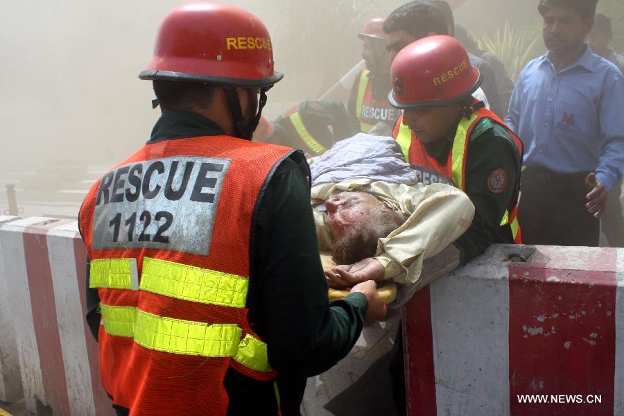 Rescuers remove a victim from the fire site in eastern Pakistan's Lahore on May 9, 2013. One killed, dozens of people reportedly trapped as fire erupted at LDA Plaza in Lahore on Thursday, local media reported. (Xinhua/Jamil Ahmed)