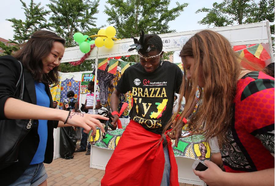 Students enjoy African dancing during the opening of the fourth International Cultural Festival held by the University of International Business and Economics (UIBE) in Beijing, capital of China, May 9, 2013. The cultural festival offered a stage for students from different countries to present their own culture. (Xinhua/Wan Xiang) 