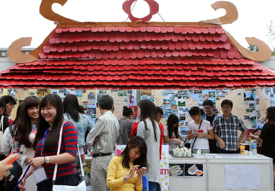 Visitors try Vietnamese snacks during the opening of the fourth International Cultural Festival held by the University of International Business and Economics (UIBE) in Beijing, capital of China, May 9, 2013. The cultural festival offered a stage for students from different countries to present their own culture. (Xinhua/Wan Xiang) 