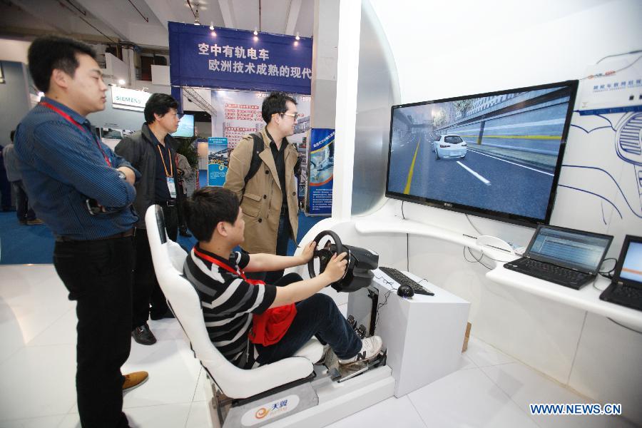 A visitor experiences the driving simulation system during the China (Shanghai) International Technology Fair in Shanghai, east China, May 8, 2013. (Xinhua/Jin Xin)