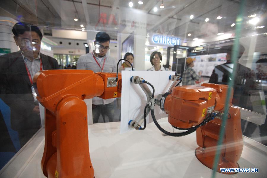 Visitors watch a smart robot drawing pictures during the China (Shanghai) International Technology Fair in Shanghai, east China, May 8, 2013. (Xinhua/Jin Xin)