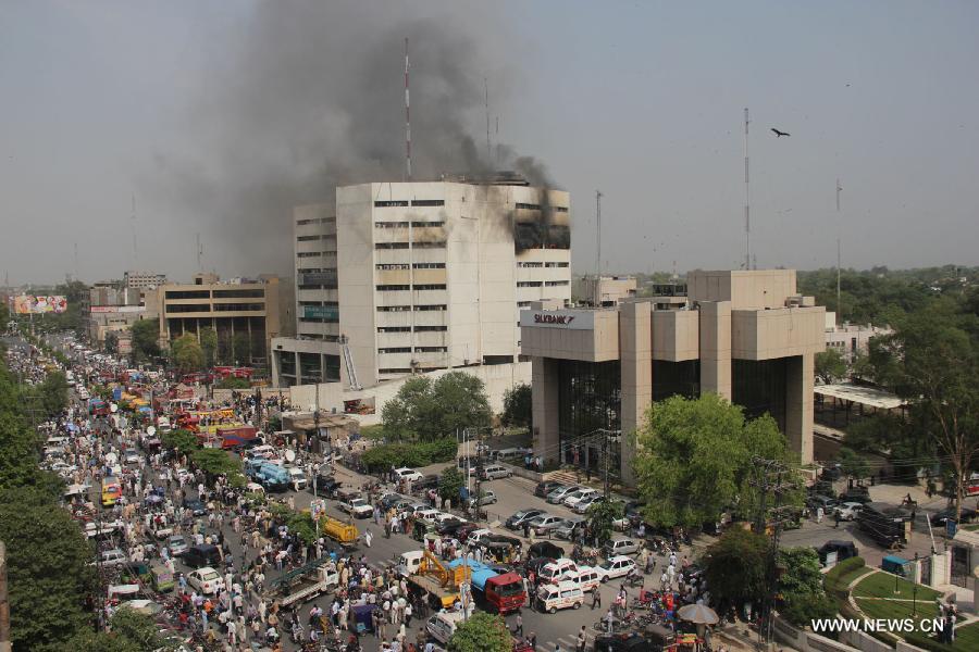 Smoke rises from the LDA Plaza in Lahore, eastern Pakistan. Fire erupted on the seventh floor of the LDA Plaza in Lahore and quickly spread to higher floors, leaving many people trapped inside the building. At least three people fell from the high floors trying to avoid the fire that engulfed the building, local media reports. (Xinhua/Jamil Ahmed)