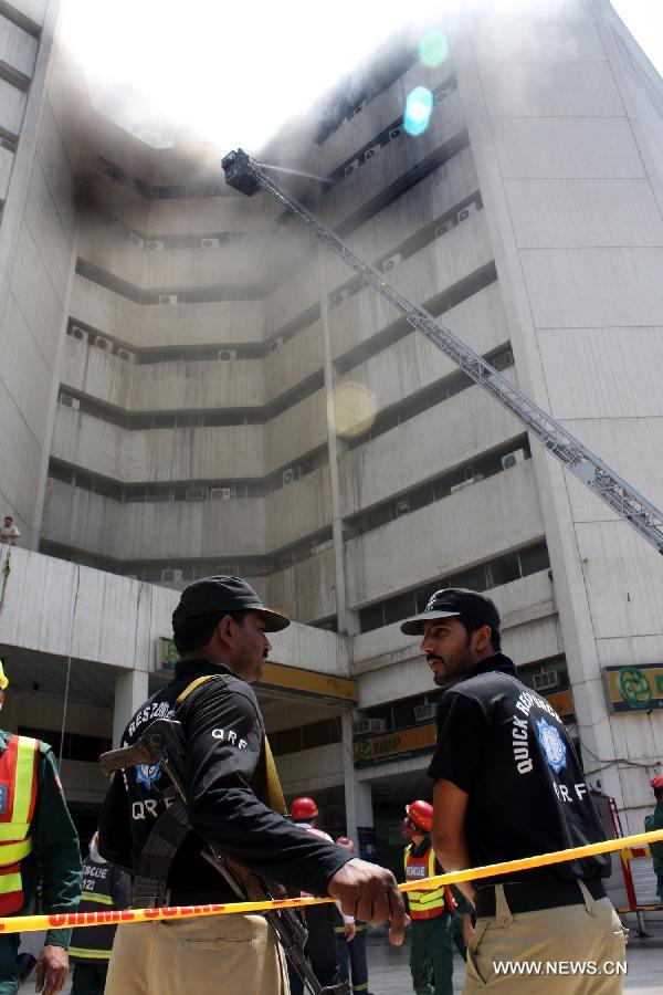 Firemen try to extinguish fire at the LDA Plaza in Lahore, eastern Pakistan. Fire erupted on the seventh floor of the LDA Plaza in Lahore and quickly spread to higher floors, leaving many people trapped inside the building. At least three people fell from the high floors trying to avoid the fire that engulfed the building, local media reports. (Xinhua/Jamil Ahmed)