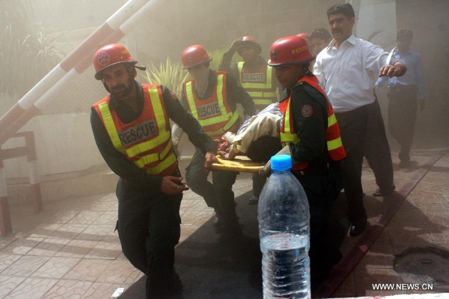 Rescuers carry a victim out of the LDA Plaza in Lahore, eastern Pakistan. Fire erupted on the seventh floor of the LDA Plaza in Lahore and quickly spread to higher floors, leaving many people trapped inside the building. At least three people fell from the high floors trying to avoid the fire that engulfed the building, local media reports. (Xinhua/Jamil Ahmed)
