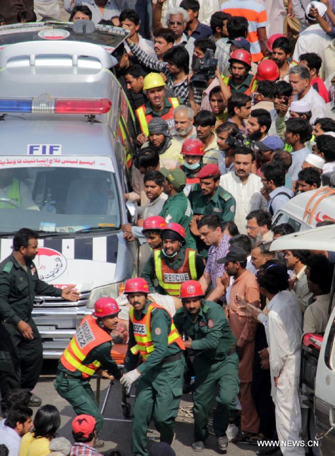 Rescuers carry a victim from the LDA Plaza in Lahore, eastern Pakistan. Fire erupted on the seventh floor of the LDA Plaza in Lahore and quickly spread to higher floors, leaving many people trapped inside the building. At least three people fell from the high floors trying to avoid the fire that engulfed the building, local media reports. (Xinhua/Jamil Ahmed)