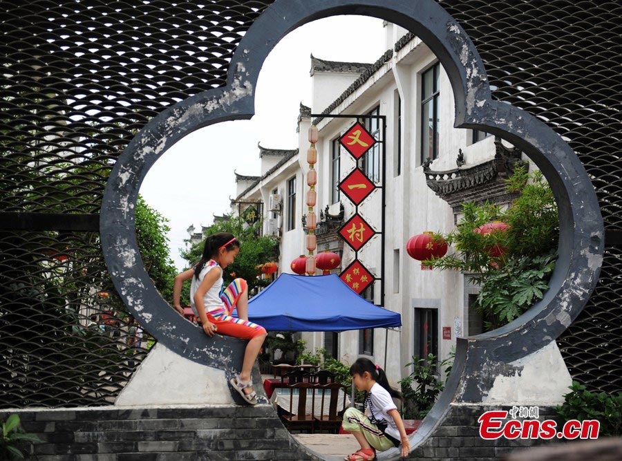 Two girls play in Baimaguan County, Luojiang, Sichuan Province. Damaged houses in Baimaguan have been restored five years after the Wenchuan earthquake, which transformed the county into a tourist attraction. In 2012, total revenue from tourism reached 186 million yuan. Baimaguan used to be a famous battlefield during the Three Kingdoms period (220 AD-280AD). (CNS/Liu Zhongjun)