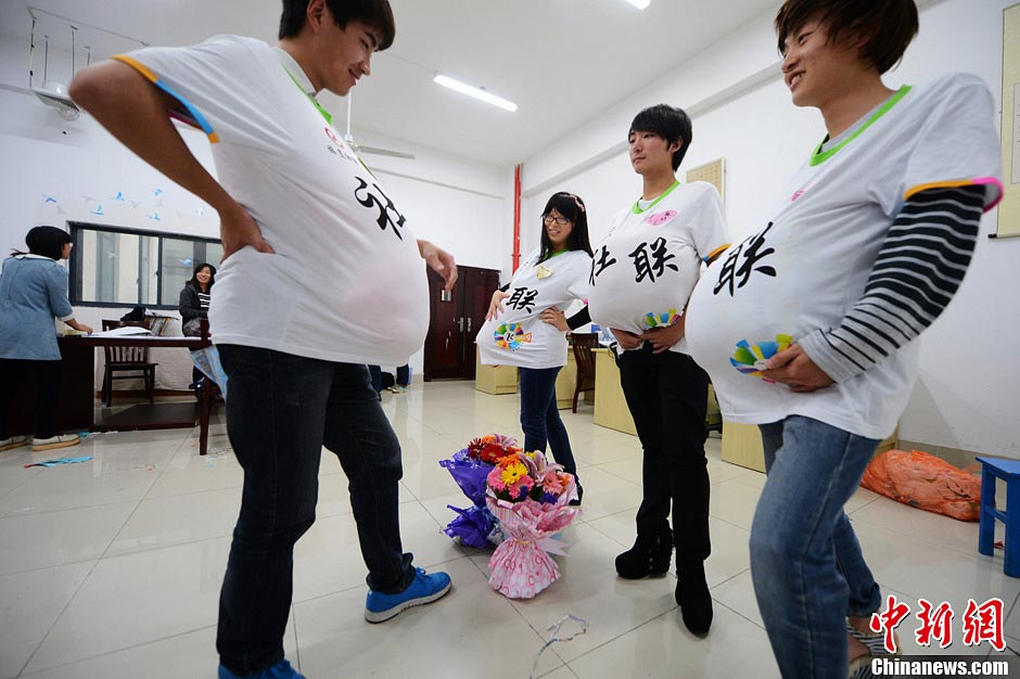 Male college students wear high heels and dress up as pregnant women to experience the hard life of a "mother-to-be" in a celebration of the upcoming Mother’s Day in Yangzhou, east China's Jiangsu province, May 9, 2013. They hope this activity will express their best wishes to mothers and "mothers-to be". (Photo/CNS)
