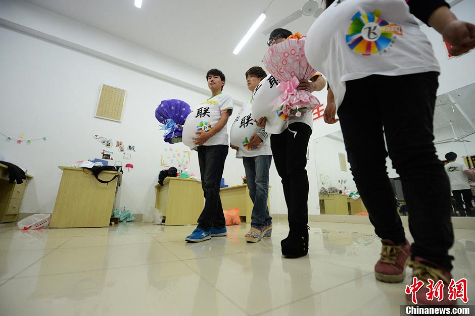 Male college students wear high heels and dress up as pregnant women to experience the hard life of a "mother-to-be" in a celebration of the upcoming Mother's Day in Yangzhou, east China's Jiangsu province, May 9, 2013. They hope this activity will express their best wishes to mothers and "mothers-to be". (Photo/CNS) 