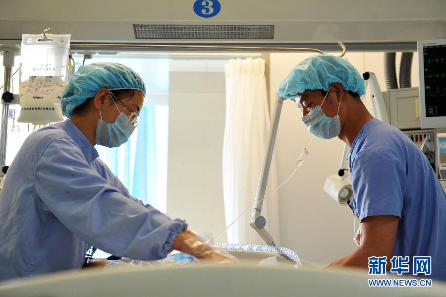 Zeng Lei and his colleague work on a patient at the affiliated hospital of Ningxia Medical University in the Ningxia Hui autonomous region, April 8. (Photo/Xinhua)